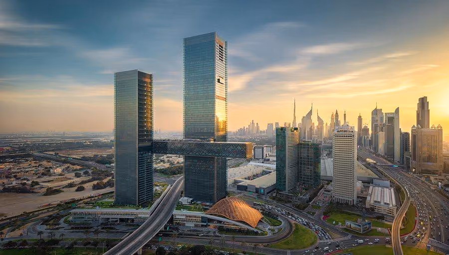 The twin towers of One Za’abeel and the suspended Link spanning between them at sunset, with the Dubai skyline and Burj Khalifa beyond.